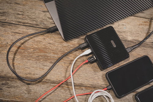 木目調デスクでスマホを複数機器同時充電する様子