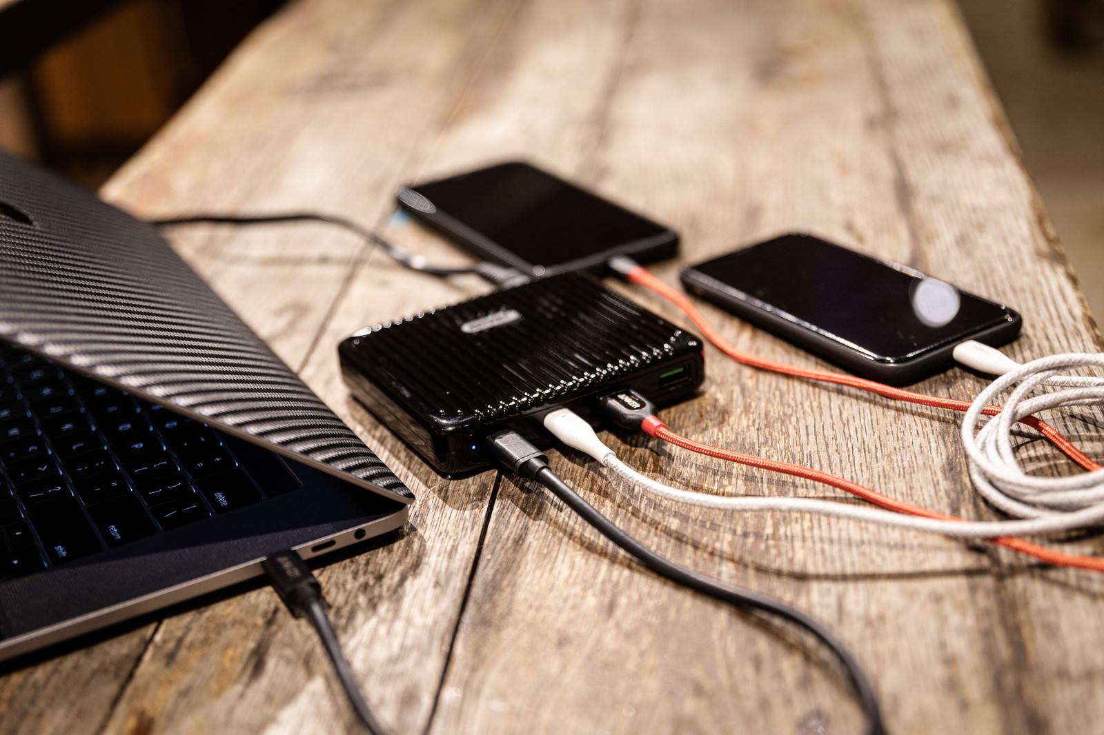 木目調の表面で複数のスマートフォンを同時充電するモバイルバッテリー