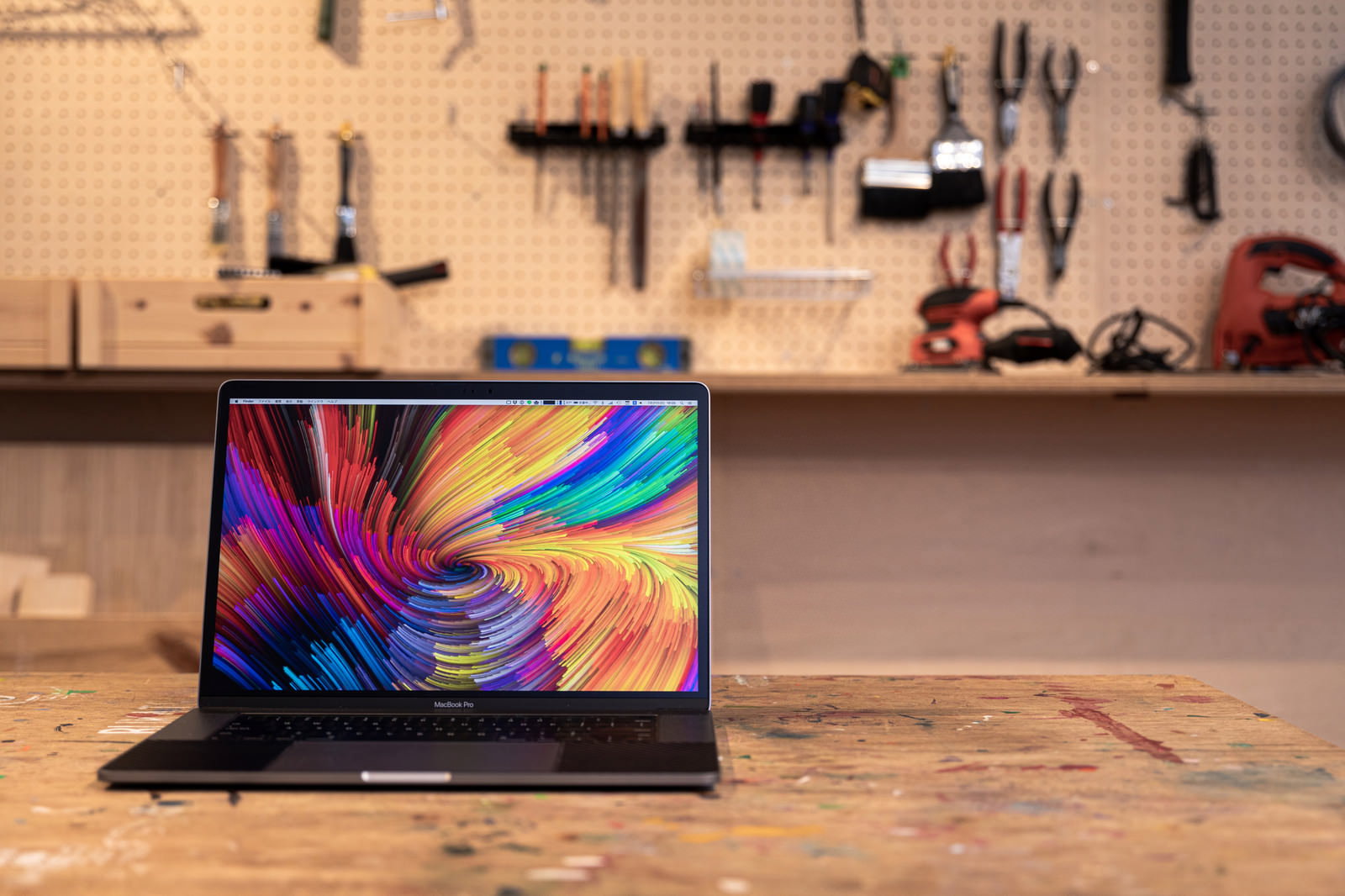 工具がある作業台の上に置かれたMacBook Pro