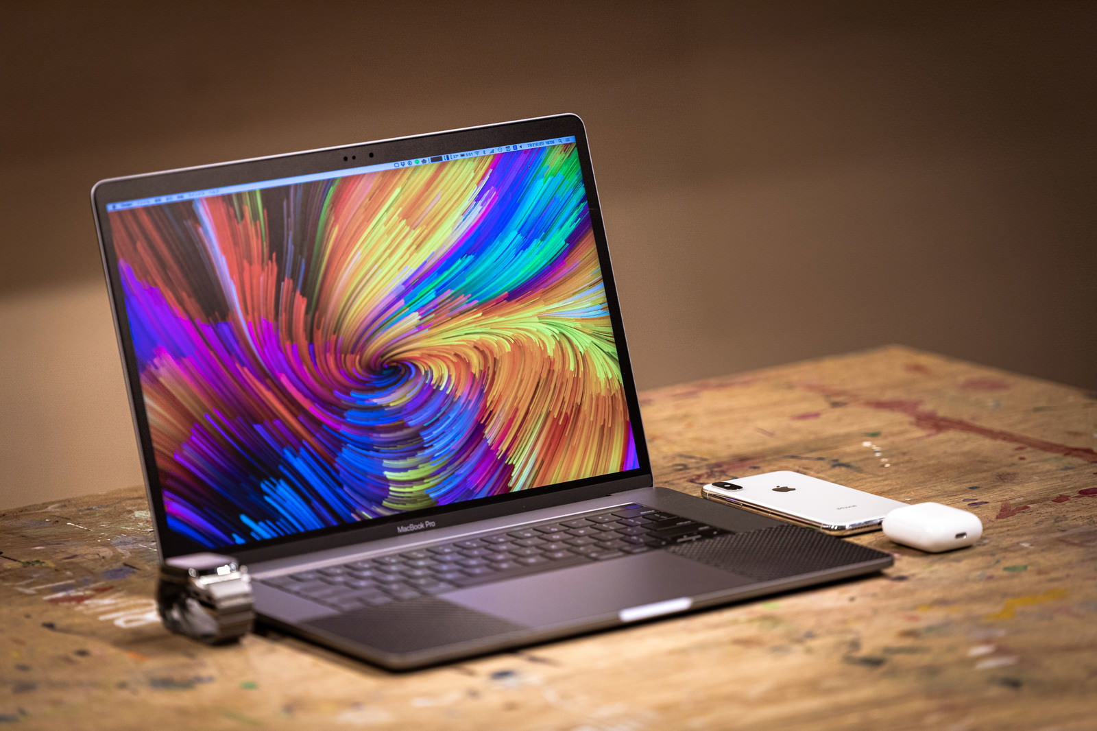 木製の作業机に開いたMacBook ProとAppleデバイス