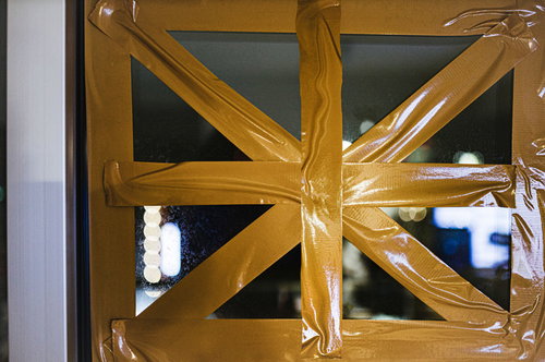 窓ガラスに黄色いガムテープで強風対策を施しました