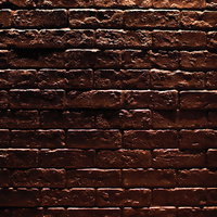 暗闇に浮かび上がるレンガの壁テクスチャーの写真