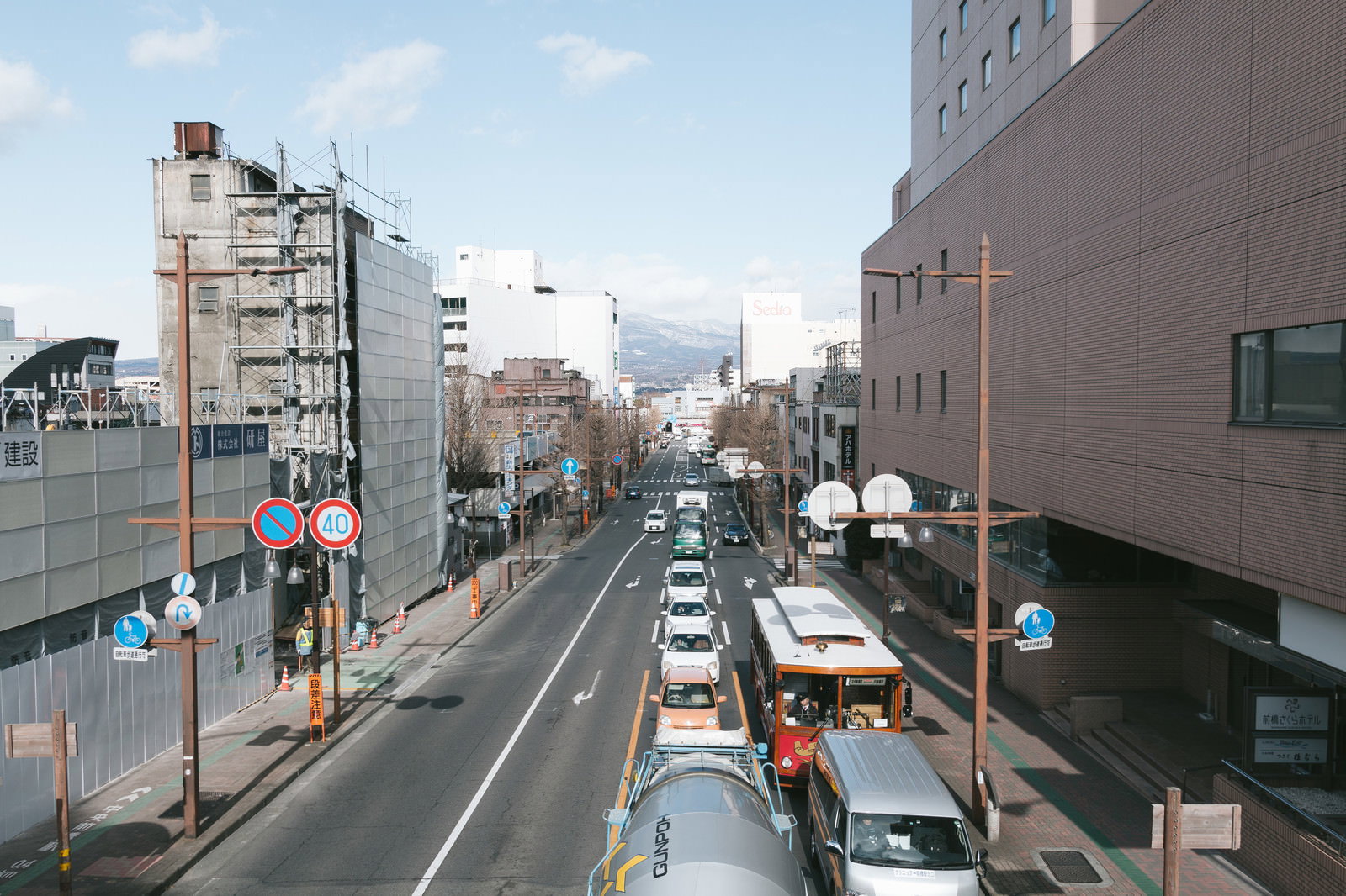 前橋駅前の広い道路を走る車と両側に立ち並ぶビルの街並み