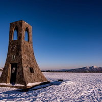 雪原に建てられた茶色い木造の避難塔の写真