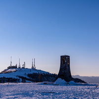 雪原に立つ黒い避難塔と電波塔の写真