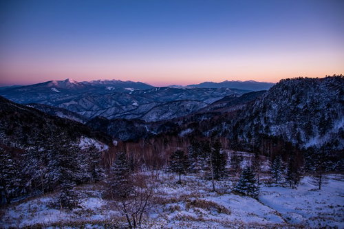 焼けた空と雪化粧の雪山が連なる冬景色