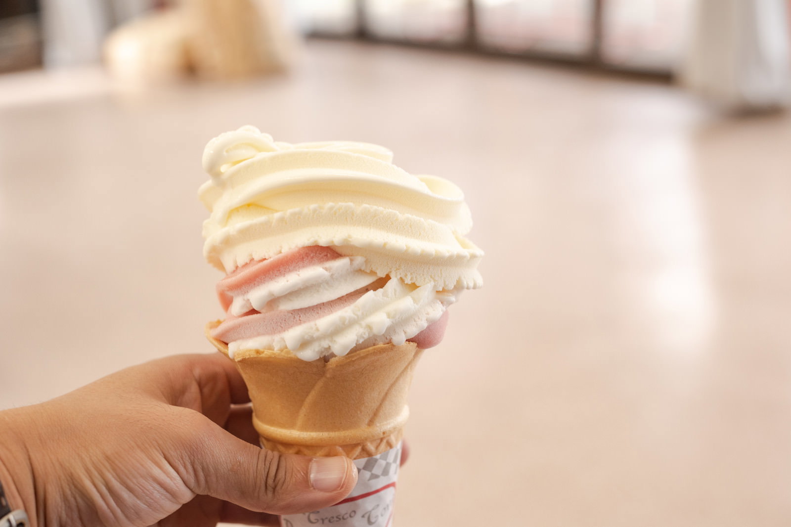 手に持たれたクリーム色のソフトクリーム
