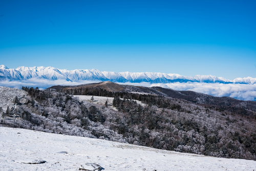 美ヶ原台上の雪景色に立ち並ぶ樹氷と雪化粧した山々