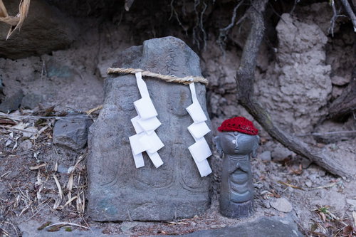 鳥屋の双体道祖神と赤い帽子の地蔵、注連縄と紙垂が飾られた洞窟内の石仏