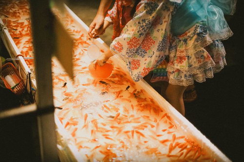 薄暗いお祭りの金魚すくい屋台の夏の風情と夜店の雰囲気