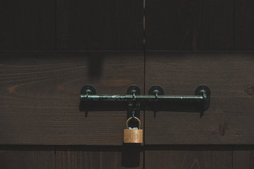 木製の扉に取り付けられた閂と南京錠