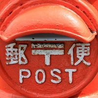 レトロな赤い丸型郵便ポストのクローズアップの写真