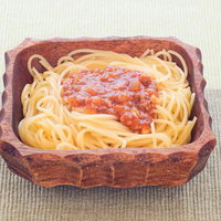 木製の器に盛りつけられたスパゲッティミートソースの写真