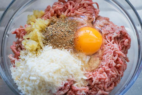 ハンバーグを作るのに合い挽き肉や卵などの材料をボウルに入れる