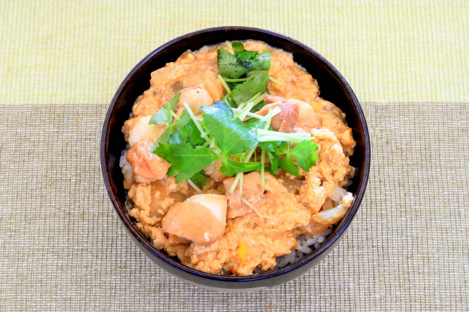 Pork cutlet bowl with three-leaf garnish in a black bowl