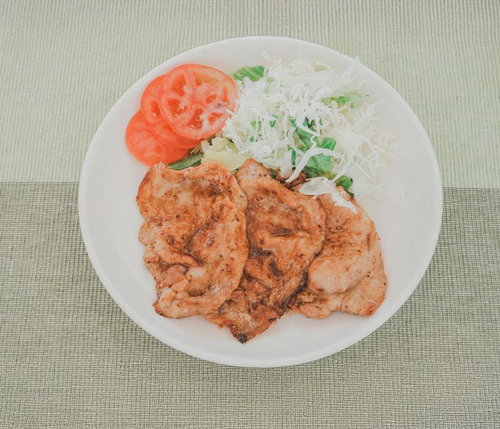 白い皿に盛られた揚げたてハムカツとキャベツの千切り