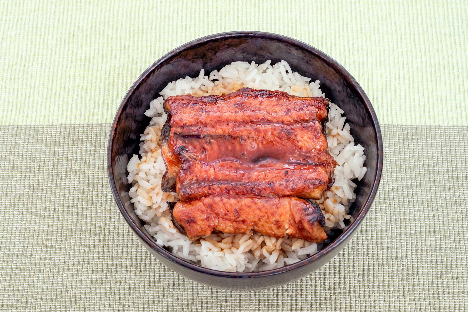 黒い丼に盛られた牛丼・紅しょうががトッピングされている