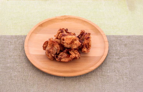 和風の黒い陶器皿に盛りつけた鶏肉と大根の煮物