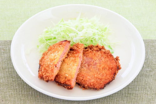 白い丸皿に盛られたベーコンとほうれん草の炒め物