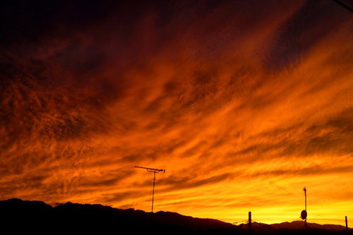 オレンジ色に染まった夜空と放送用アンテナのシルエット