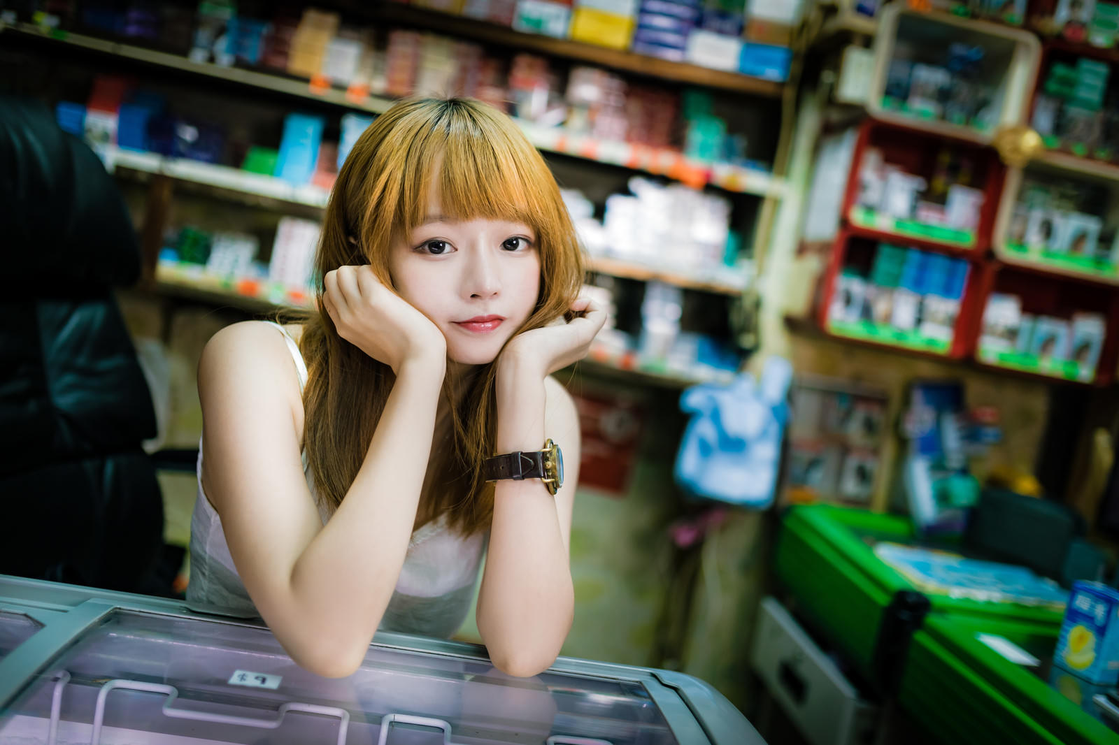 香港の商店で頬杖をついて店番をするプリン髪の美少女