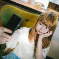 スマートフォンで笑顔の自撮りをする若い女性の写真