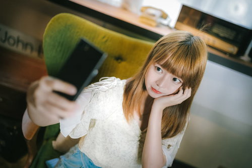 スマートフォンで笑顔の自撮りをする若い女性