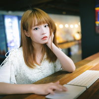 いい案が出ずにノートパソコンの前で頭を抱える女性の写真