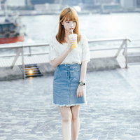 ジュースを飲みながらお散歩する女子のカジュアルコーディネートの写真