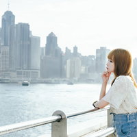 ビクトリアハーバー（香港）を見つめながら黄昏れる失恋美女の写真