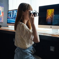 コワーキングスペースでカメラを構えるカメラ女子の写真