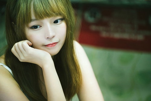 頬杖をついてにっこり笑う香港美女のポートレート