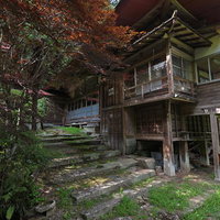 東堂山満福寺の境内、紅葉に包まれた石階段と木造建築の写真