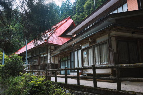 赤い屋根の社と緑に囲まれた東堂山満福寺境内