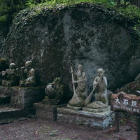 東堂山満福寺の苔むした大石垣と石像、石段の写真