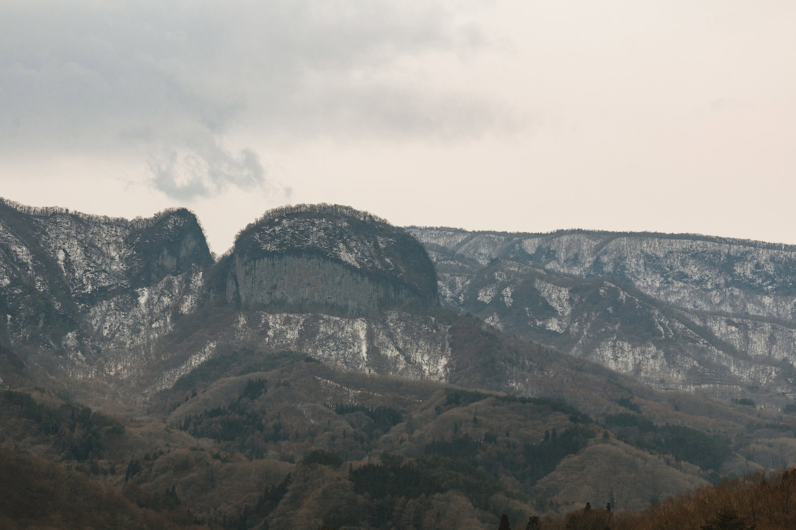 曇り空の下に連なる八ッ場ダム周辺の岩山風景