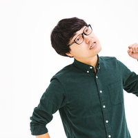 腕を振り上げて悔しがるメガネの男性の写真