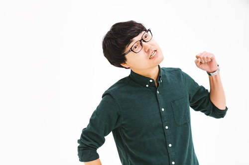 腕を振り上げて悔しがるメガネの男性