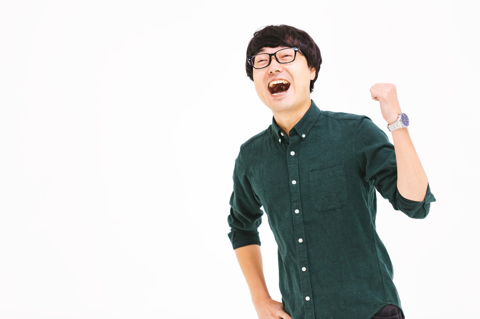 緑色のシャツを着てガッツポーズをする笑顔のメガネ男性［モデル：真崎真幸］