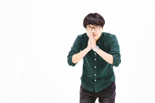 一生のお願いごめんなさいと手を合わせてお辞儀をする男性