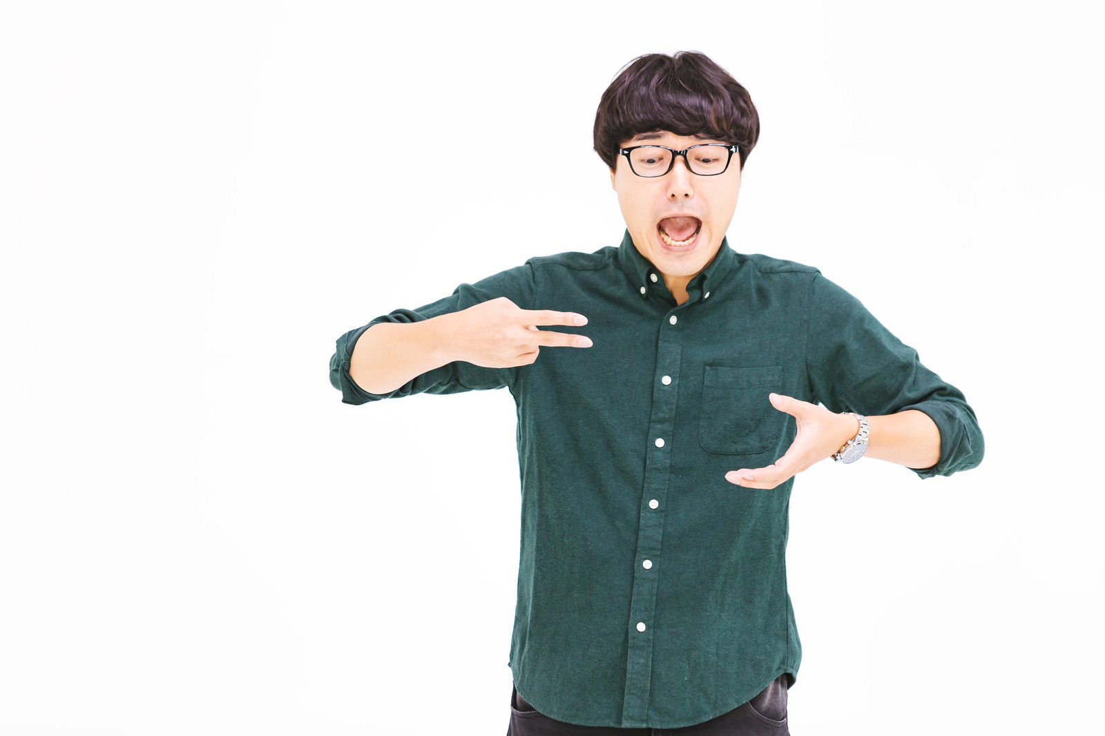 緑色のシャツを着た眼鏡の男性が両手でポーズを取る［モデル：真崎真幸］