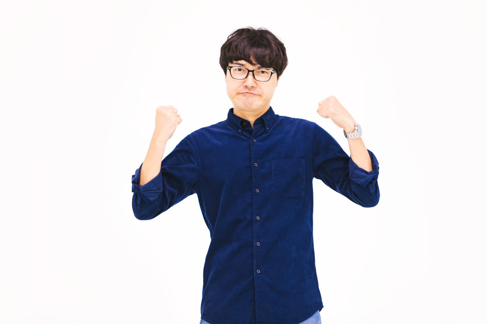 紺色のシャツを着た男性が両手を上げてガッツポーズをしている［モデル：真崎真幸］