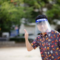 公園の散歩にもフェイスシールドでいいね、グッジョブサインをする男性の写真