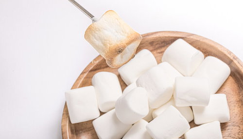 木製のボウルに入った表面をこんがり焼いたマシュマロ