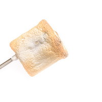 串に刺した焼きマシュマロ。こんがり焼けたふわふわスイーツの写真