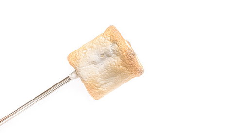 串に刺した焼きマシュマロ。こんがり焼けたふわふわスイーツ