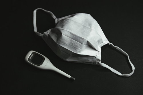 白いサージカルマスクと電子体温計による感染症対策と健康管理