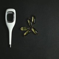 風邪対策に欠かせない体温計とビタミン剤の健康管理の写真