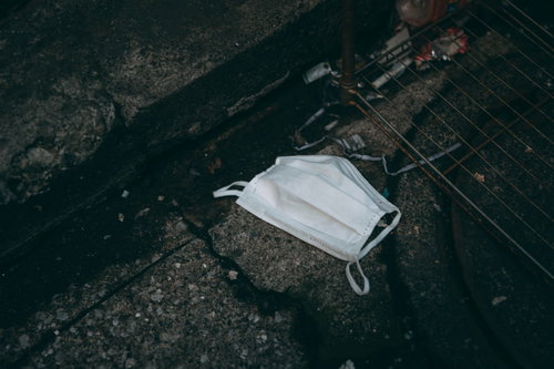アスファルトに落ちているポイ捨てマスクの環境汚染