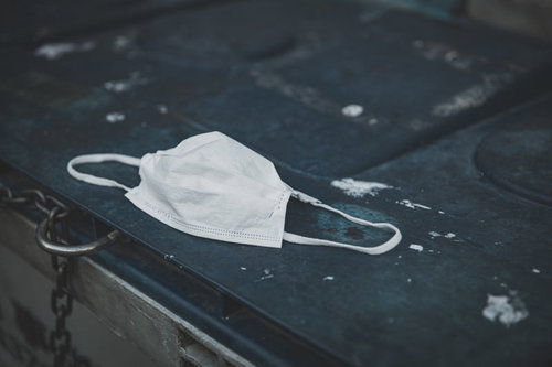 アスファルトの上に捨てられた白いマスク